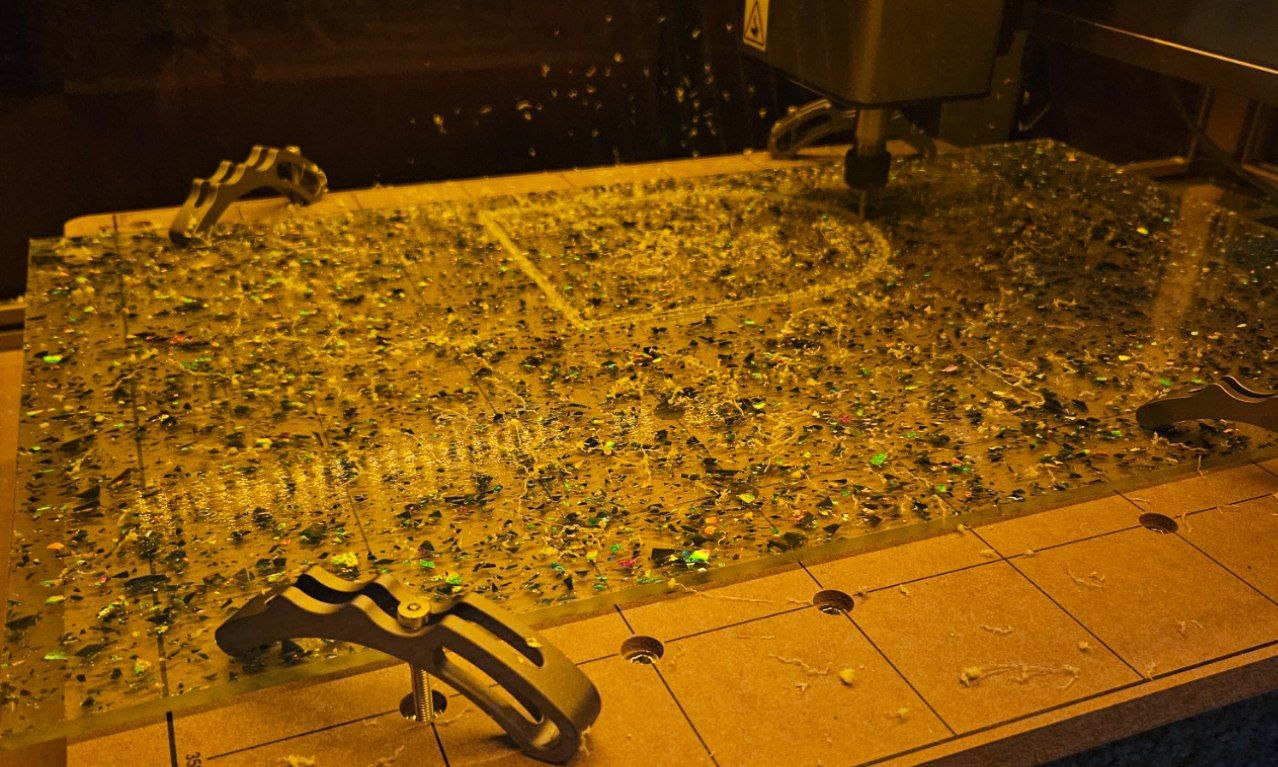 CNC machine cutting through glitter acrylic sheet