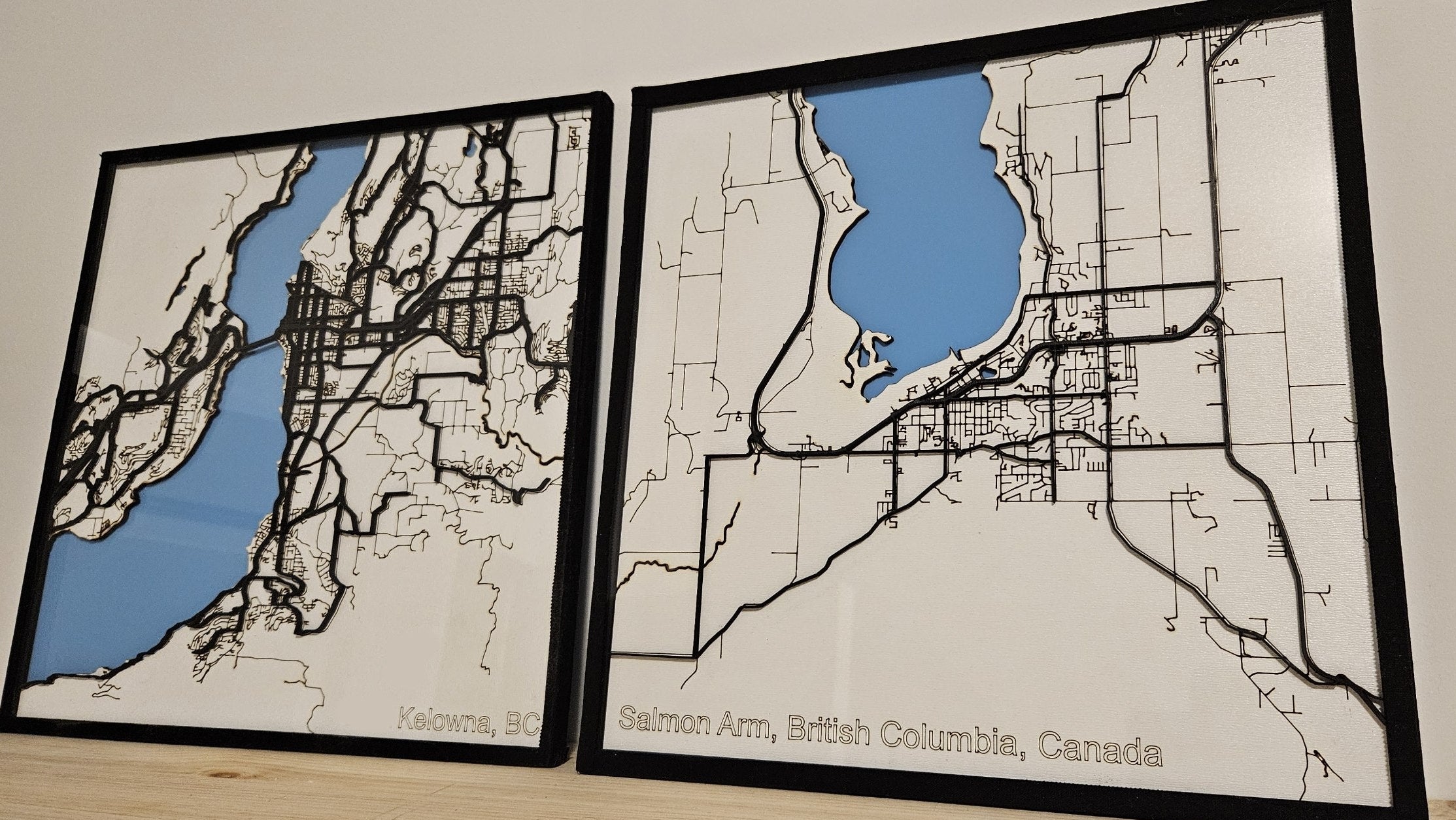 Two framed maps of Vancouver, British Columbia, Canada on a plain background