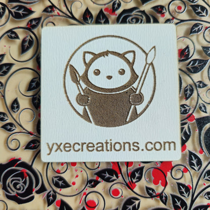 Card with a cute character design and 'yxecreations.com' text on a decorative background with Black Roses and Red Paint