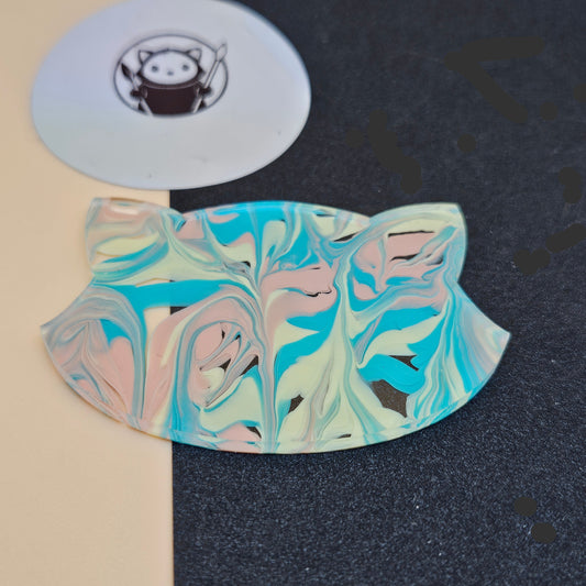 Cotton Candy Tides Acrylic Swatch on a dark surface with a circular white object featuring a logo.