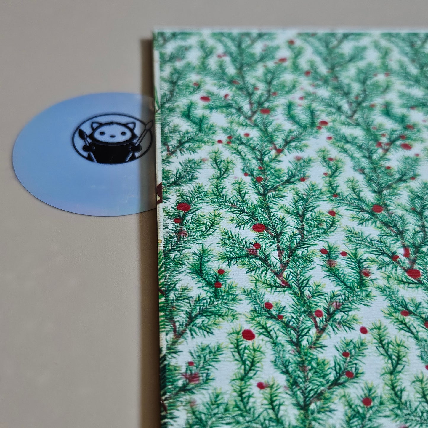 Close-up of a Next Level Sheet Acrylic with a Christmas tree pattern and a blue label with a logo.