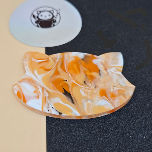 Marbled Orange Tides Acrylic Swatch on a textured black and beige surface